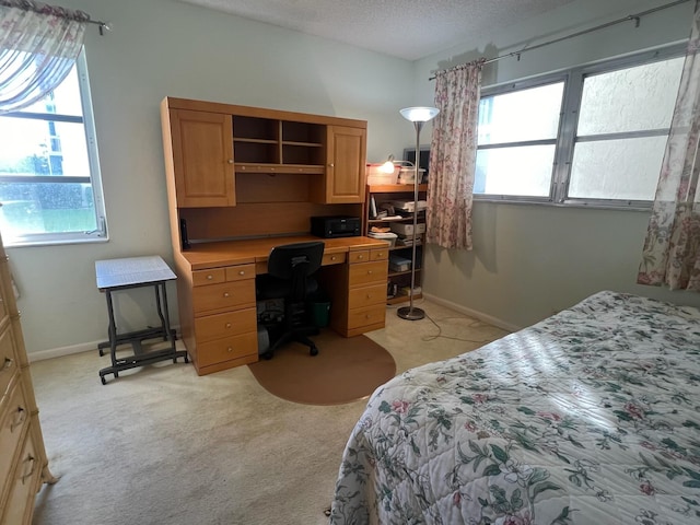 bedroom with light colored carpet and a textured ceiling