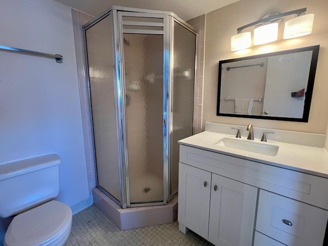 bathroom with vanity, toilet, tile patterned flooring, and a shower with door