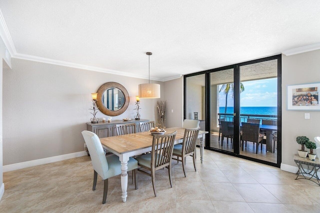 dining space with light tile patterned flooring, ornamental molding, a wall of windows, and a water view