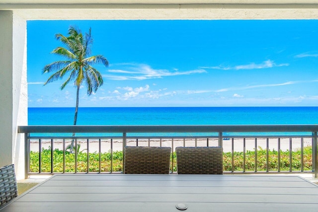 balcony with a water view and a beach view