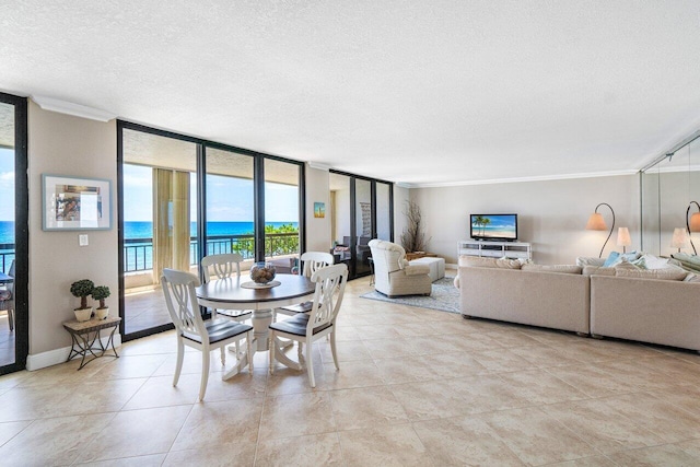 tiled dining room with crown molding, floor to ceiling windows, a textured ceiling, and a water view