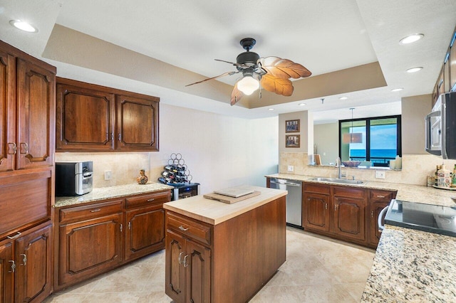 kitchen with stainless steel appliances, a raised ceiling, and sink