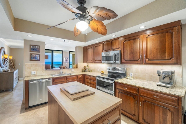 kitchen featuring tasteful backsplash, a center island, appliances with stainless steel finishes, and sink