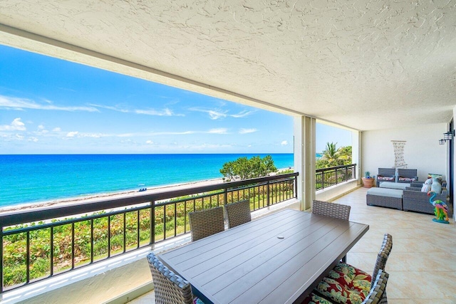 balcony with a water view, a beach view, and an outdoor hangout area