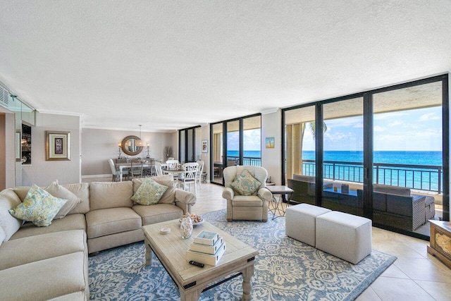 living room with light tile patterned floors, crown molding, a wall of windows, a water view, and a textured ceiling