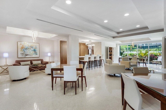 dining space featuring a raised ceiling and expansive windows