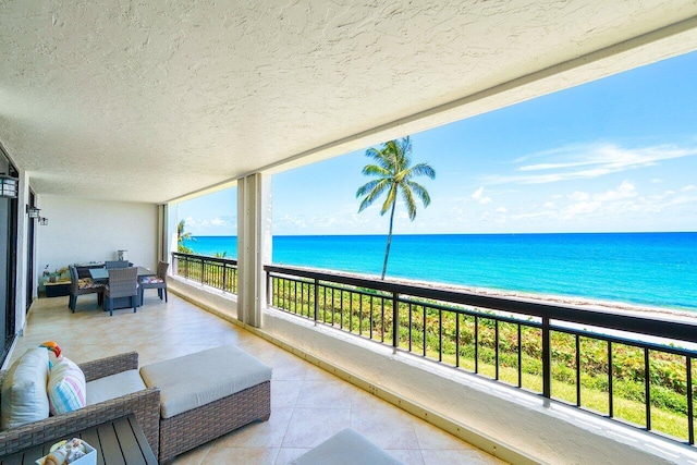 balcony with a water view and a beach view