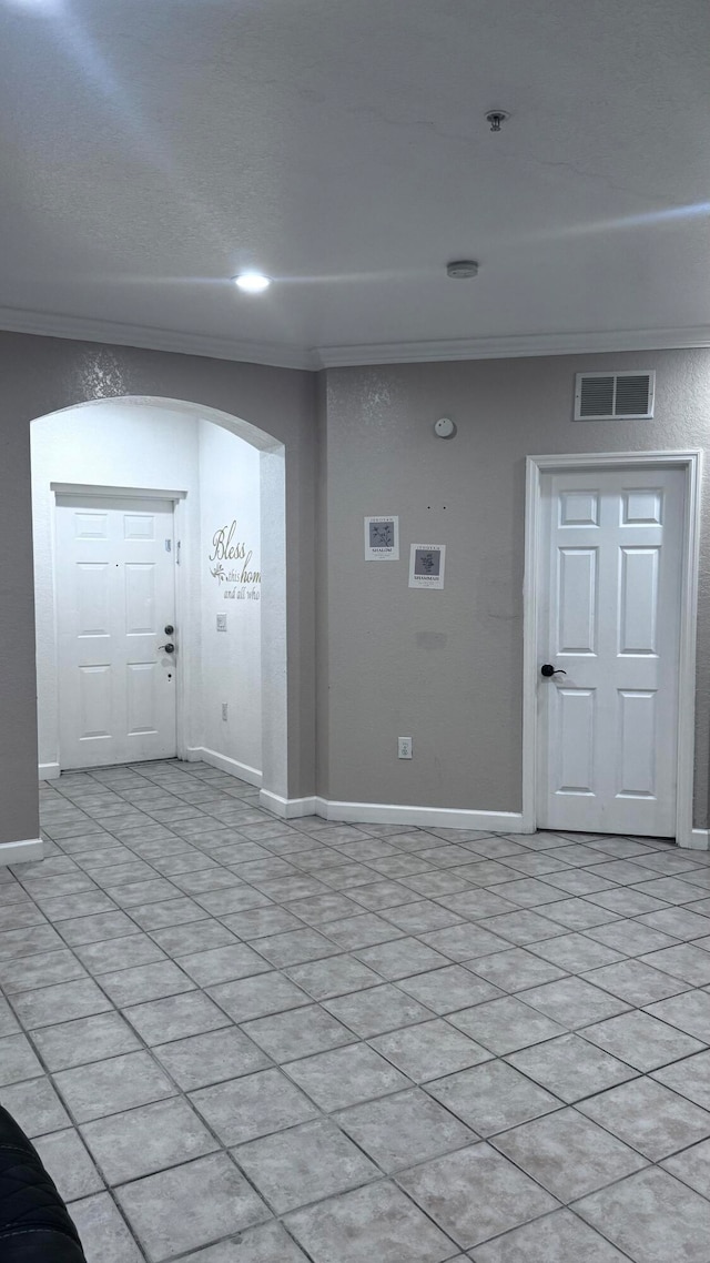 tiled entryway featuring crown molding