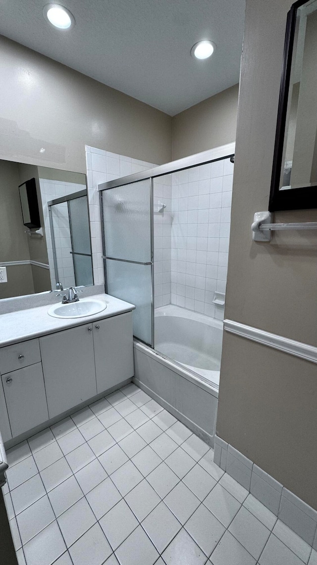 bathroom featuring vanity, tile patterned flooring, and enclosed tub / shower combo