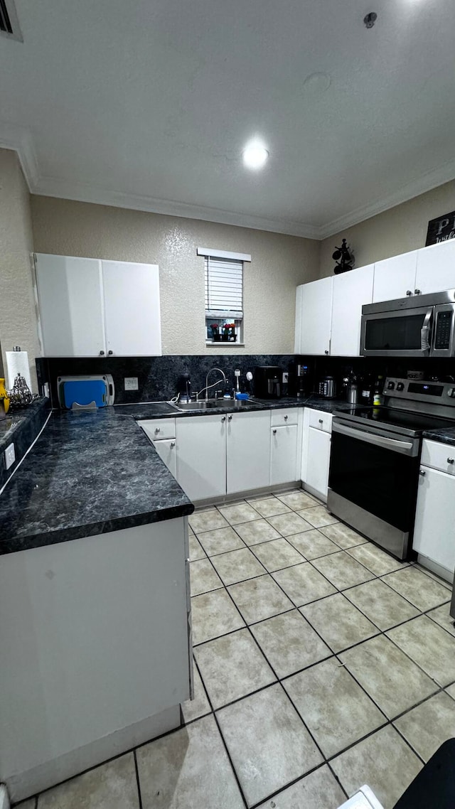 kitchen featuring stainless steel appliances, sink, light tile patterned floors, decorative backsplash, and ornamental molding