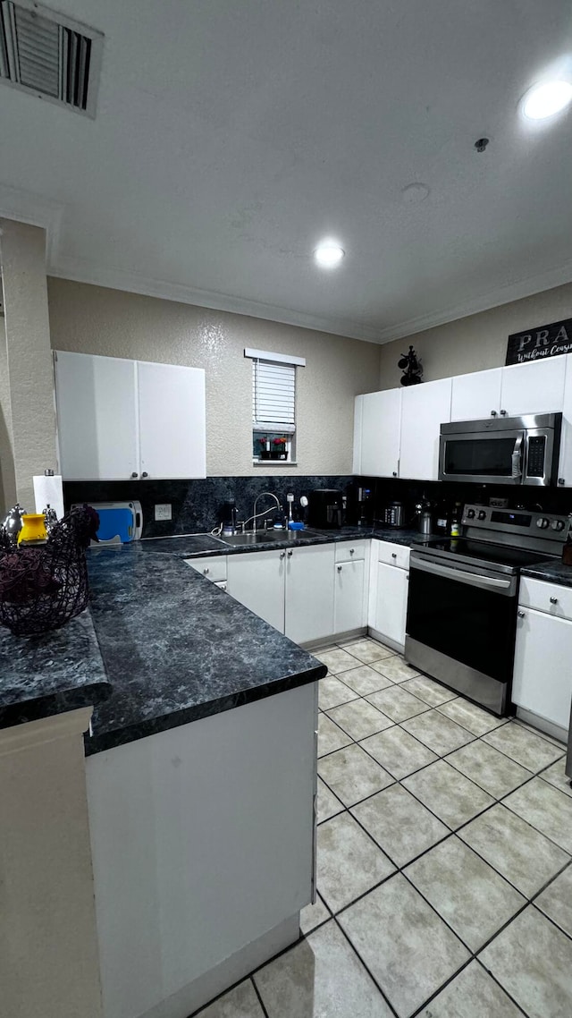 kitchen featuring light tile patterned flooring, stainless steel appliances, backsplash, and sink