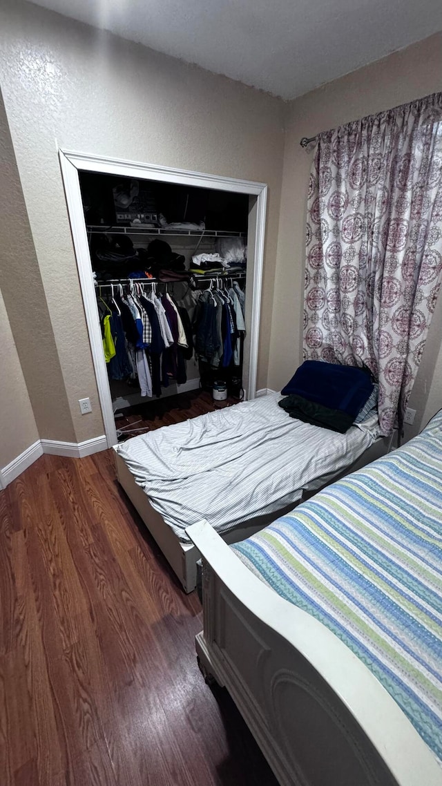 bedroom with a closet and hardwood / wood-style floors