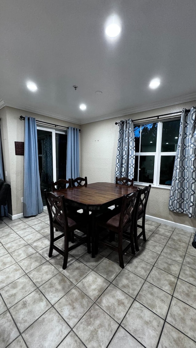 tiled dining space featuring ornamental molding