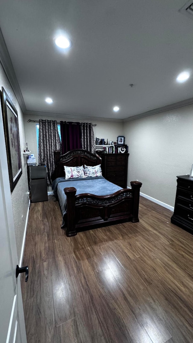 bedroom with ornamental molding and hardwood / wood-style floors