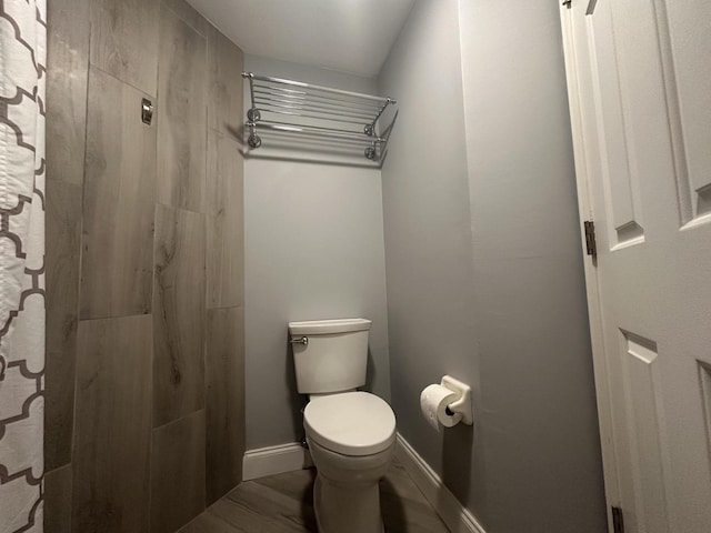 bathroom featuring hardwood / wood-style flooring and toilet