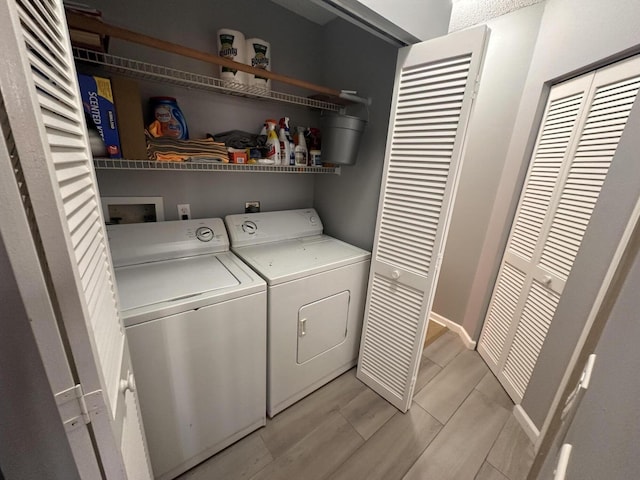 laundry room with independent washer and dryer and light hardwood / wood-style floors