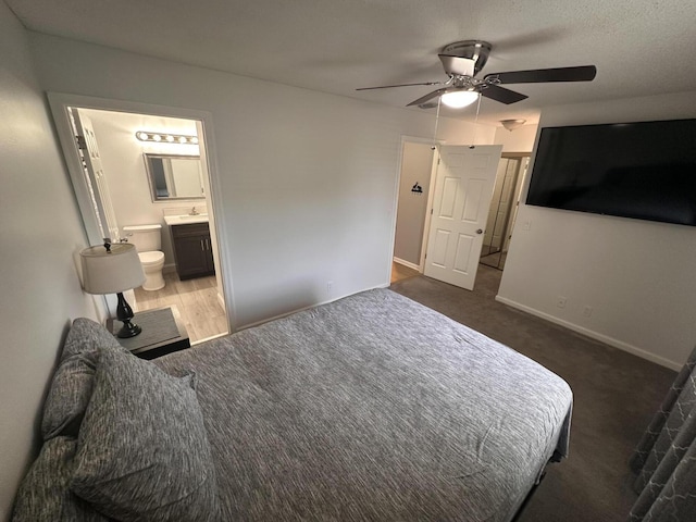 carpeted bedroom featuring ceiling fan, ensuite bathroom, and sink