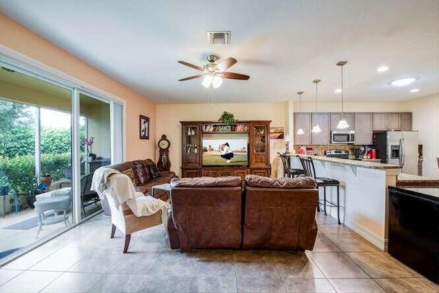 living room featuring ceiling fan, light tile patterned flooring, and visible vents