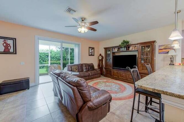 living room featuring light tile patterned floors, visible vents, and a ceiling fan