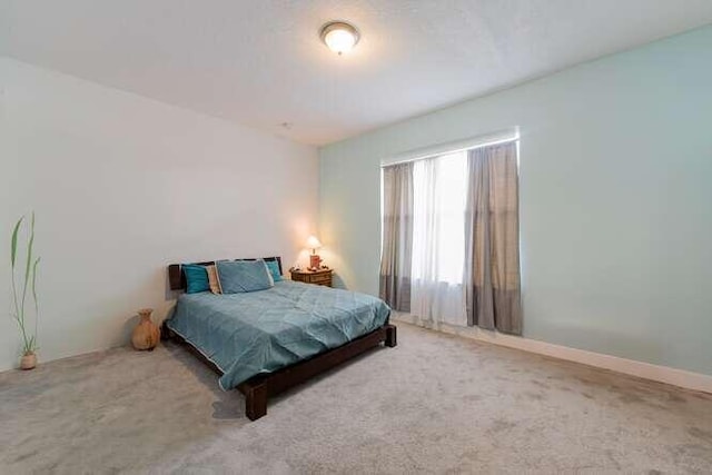 bedroom featuring carpet floors and baseboards