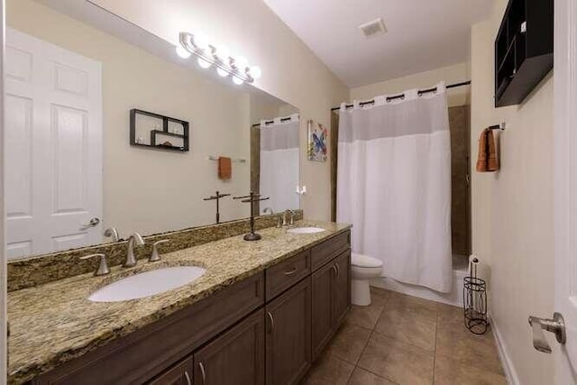 full bathroom with tile patterned flooring, a sink, toilet, and double vanity