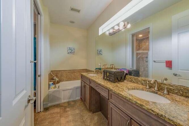 bathroom featuring a stall shower, double vanity, a sink, and a bath