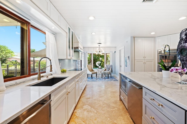 kitchen with decorative light fixtures, white cabinets, and a healthy amount of sunlight