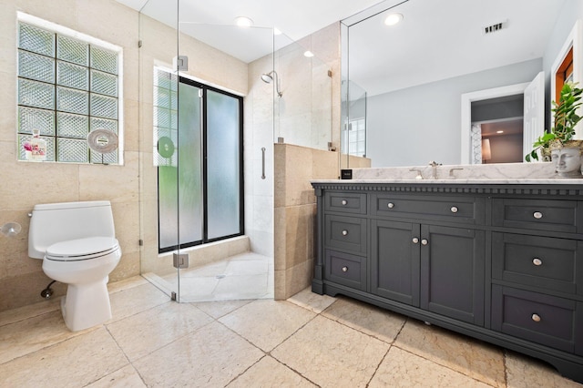 bathroom featuring tile walls, tile patterned flooring, and toilet