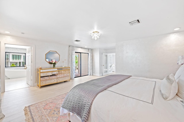 bedroom with ensuite bathroom, light hardwood / wood-style floors, and access to exterior