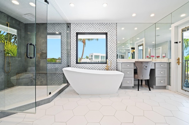 bathroom with tile patterned flooring, tile walls, vanity, and independent shower and bath