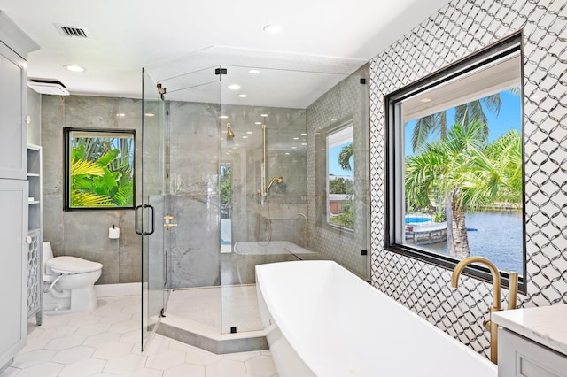 full bathroom with vanity, tile walls, a healthy amount of sunlight, and tile patterned flooring