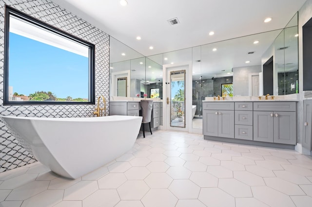 bathroom with a tub, vanity, and tile patterned flooring