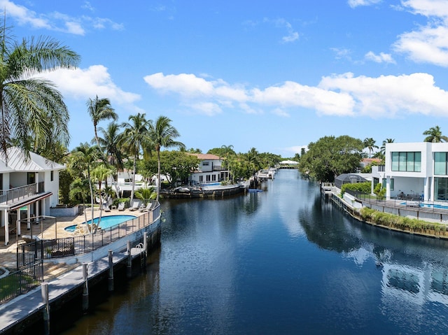 view of dock with a patio, a water view, a community pool, and a balcony