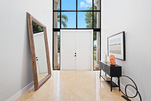 tiled foyer featuring a high ceiling and a healthy amount of sunlight