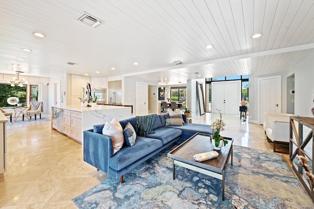 tiled living room featuring a notable chandelier, a barn door, plenty of natural light, and wooden ceiling