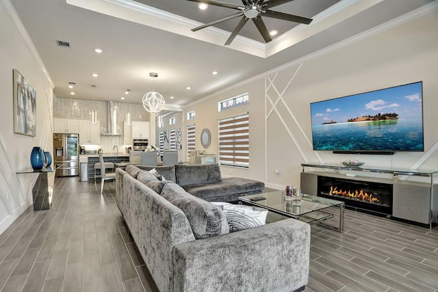 living room with crown molding and ceiling fan