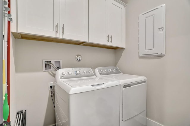 laundry room with independent washer and dryer, cabinets, and electric panel