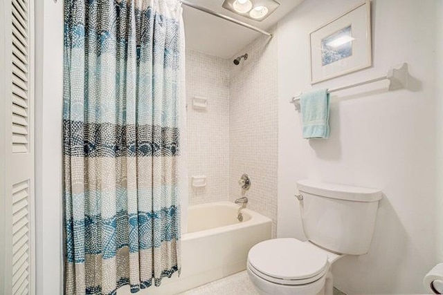 bathroom featuring shower / bathtub combination with curtain and toilet