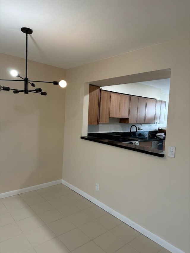 kitchen featuring a notable chandelier, pendant lighting, and sink