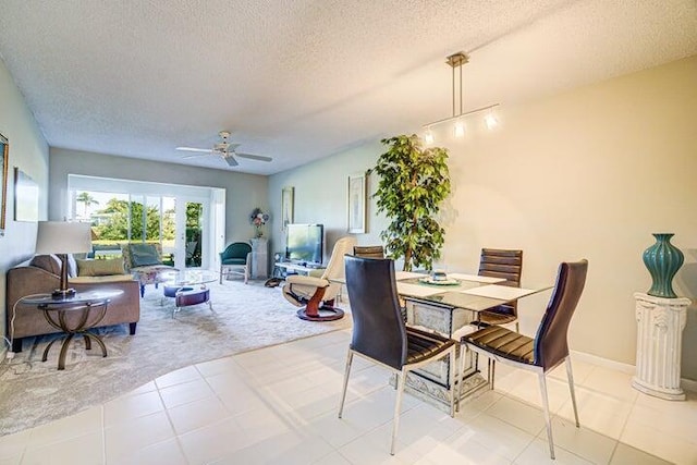 tiled dining area featuring ceiling fan and a textured ceiling