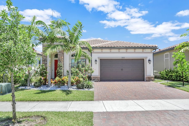 mediterranean / spanish house featuring a garage and a front yard