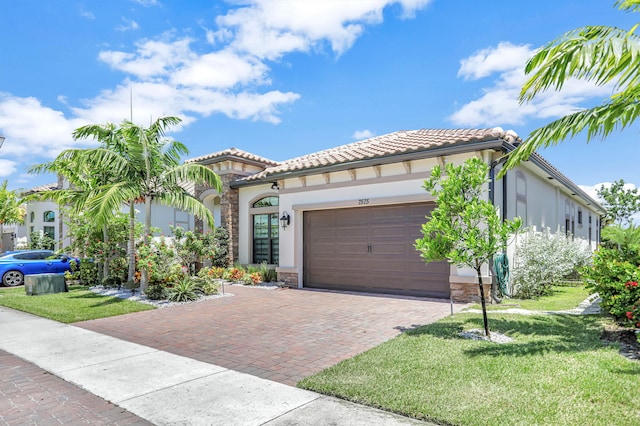 mediterranean / spanish home featuring a garage and a front yard