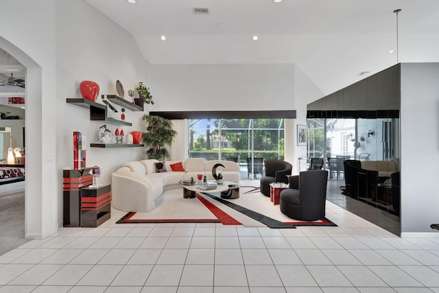 living room with high vaulted ceiling, ceiling fan, and light tile patterned floors