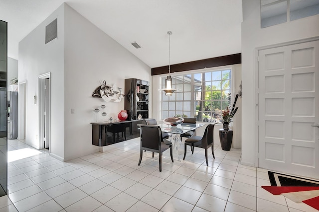 dining room with light tile patterned floors and high vaulted ceiling