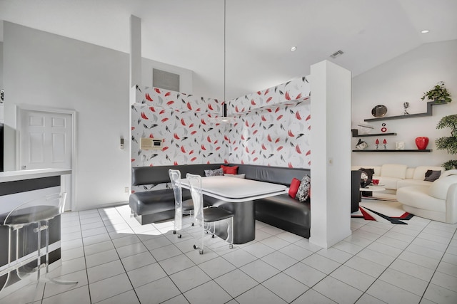 dining area featuring lofted ceiling and light tile patterned floors