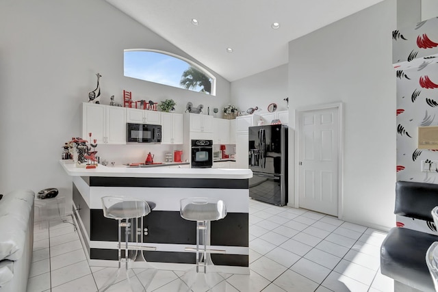 kitchen featuring light tile patterned flooring, white cabinetry, kitchen peninsula, black appliances, and high vaulted ceiling