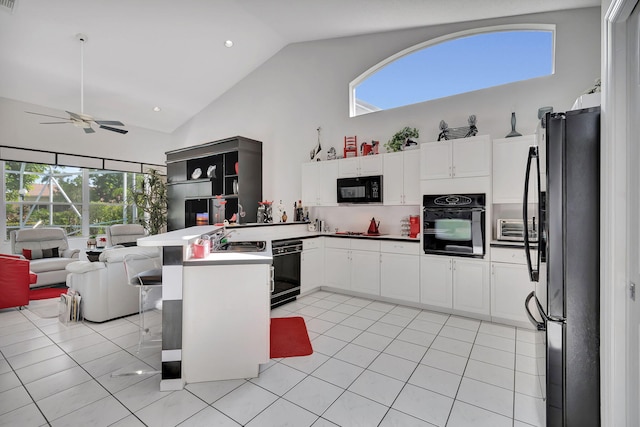 kitchen with light tile patterned floors, kitchen peninsula, fridge, ceiling fan, and wall oven