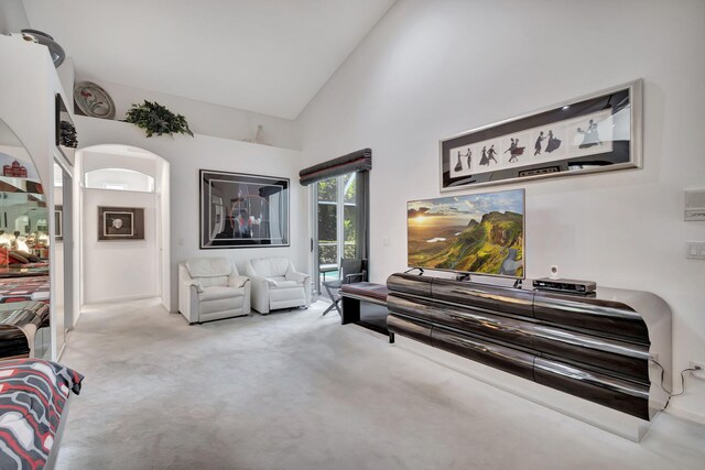 interior space with light colored carpet and high vaulted ceiling