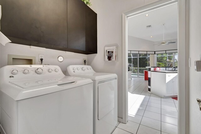 clothes washing area with light tile patterned flooring, washer and clothes dryer, cabinets, and ceiling fan