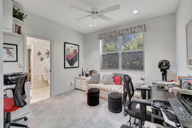 carpeted office with a textured ceiling and ceiling fan